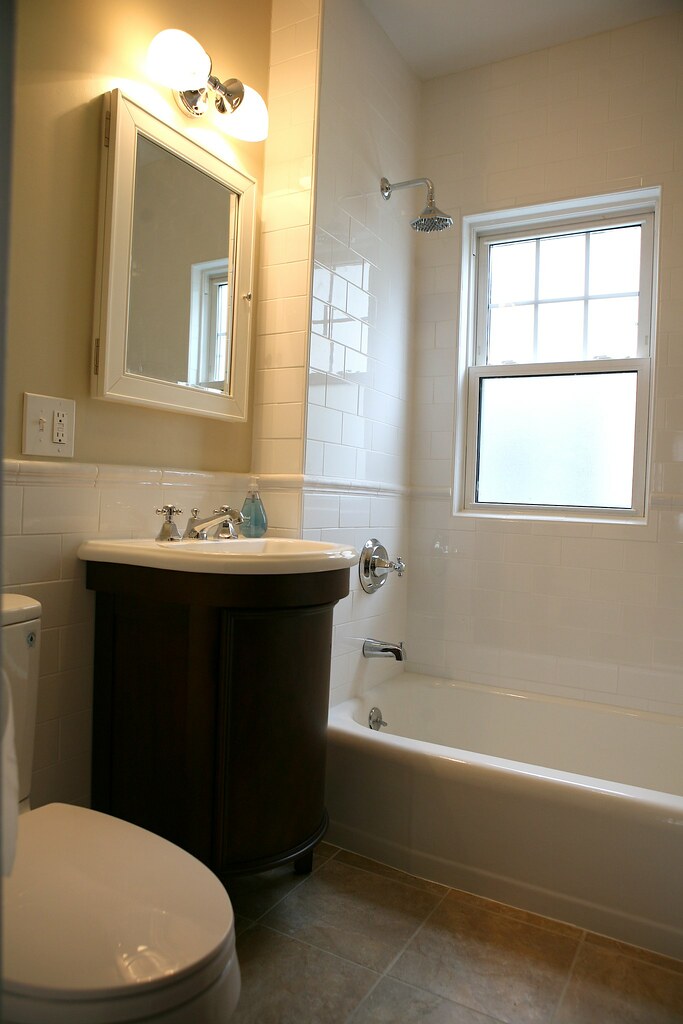 Bathroom renovation with a tiled shower over bath and vanity