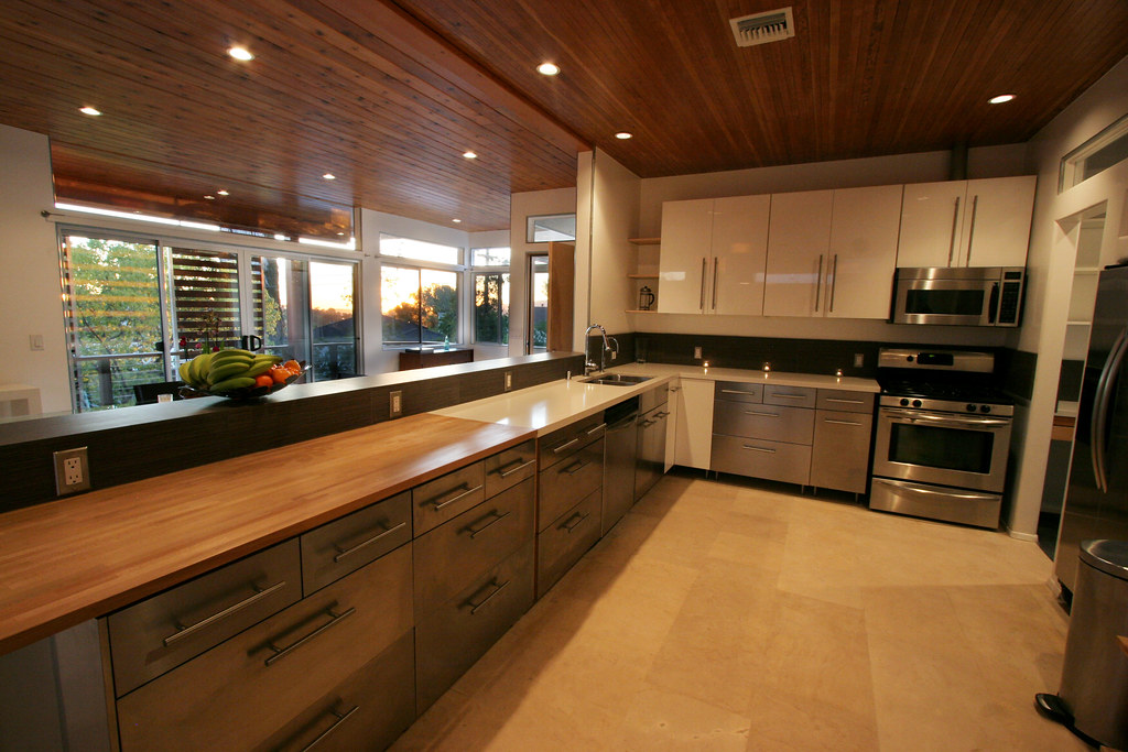 Modern open plan kitchen renovation with stainless appliances and a timber benchtop