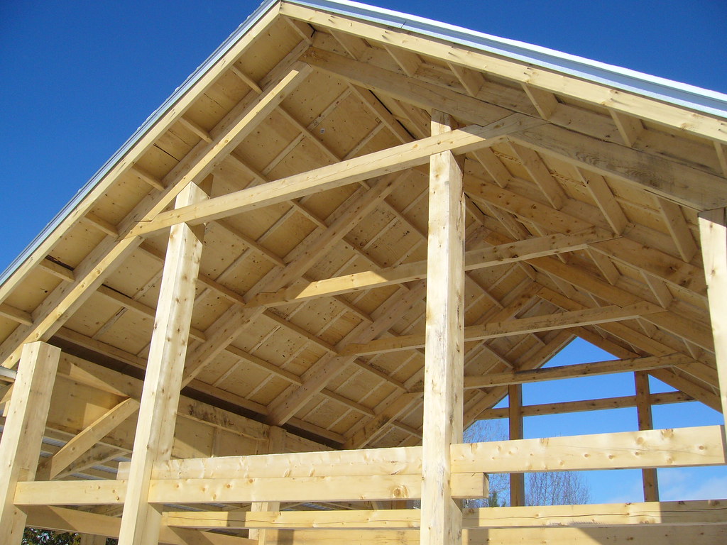 Timber frame roof structure against a clear sky